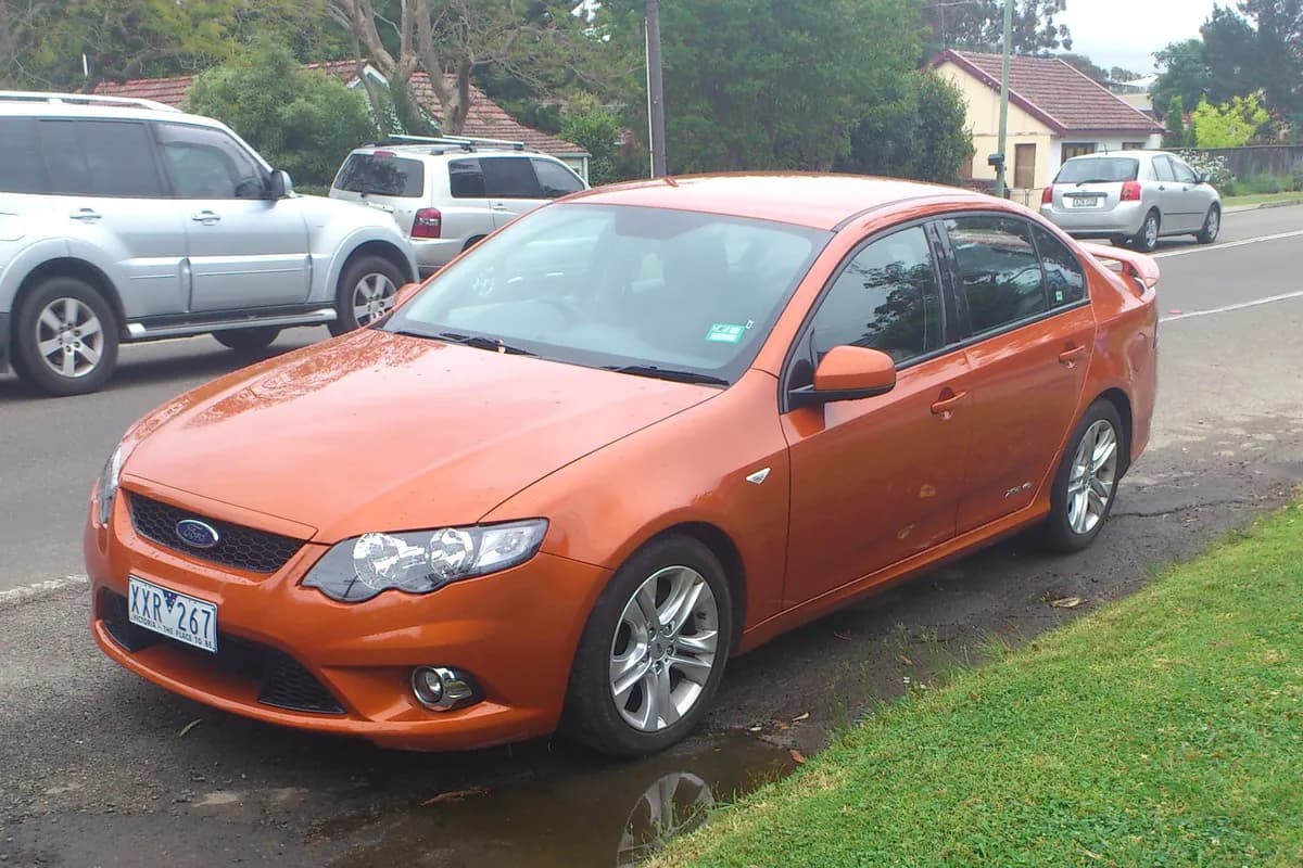 An orange Ford Falcon sedan, front three-quarter view