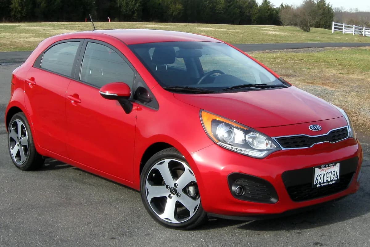 A red Kia Rio hatchback, front three-quarter view