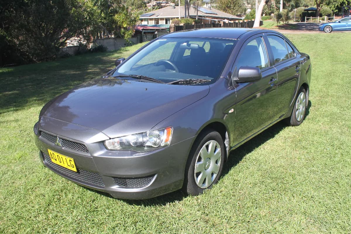 A grey Mitsubishi Lancer sedan, front three-quarter view